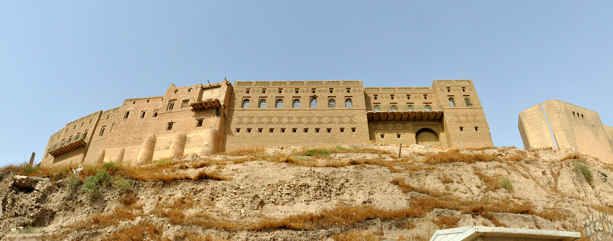 The brick wall of the Erbil citadel seen from the slope below it